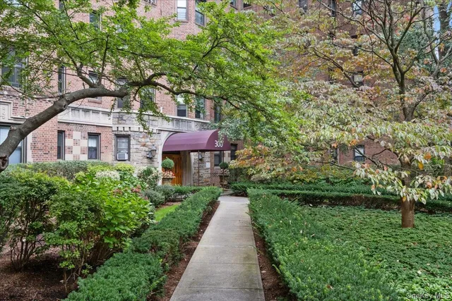 a front view of a house with a yard and fountain
