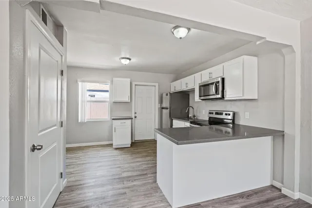 a kitchen with stainless steel appliances a refrigerator sink and microwave