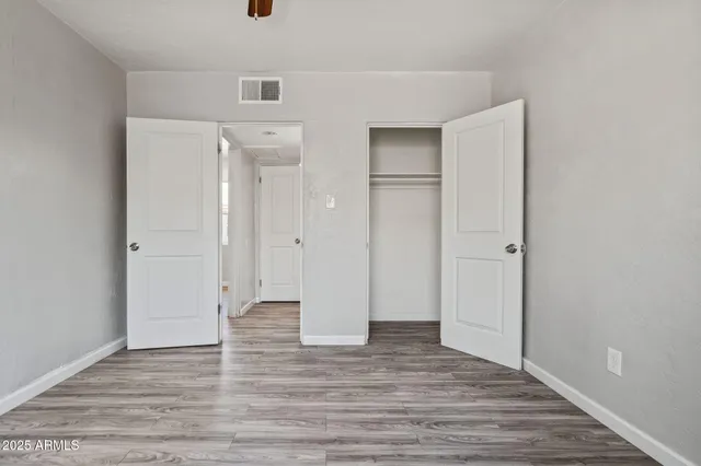 a view of empty room with wooden floor