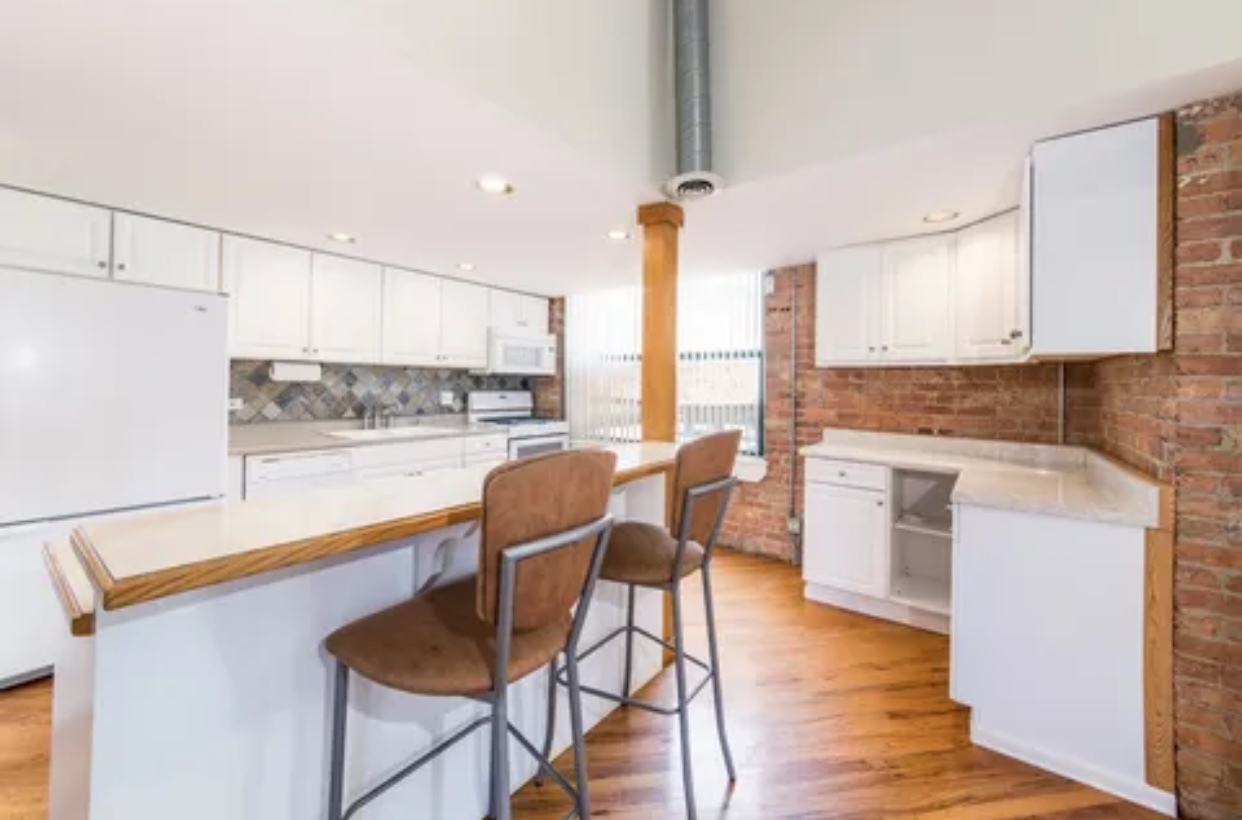 1439 South Michigan Avenue, Unit 101 Chicago, IL 60605 - Photo 6 of 14 a kitchen with stainless steel appliances a dining table chairs a sink and white cabinets