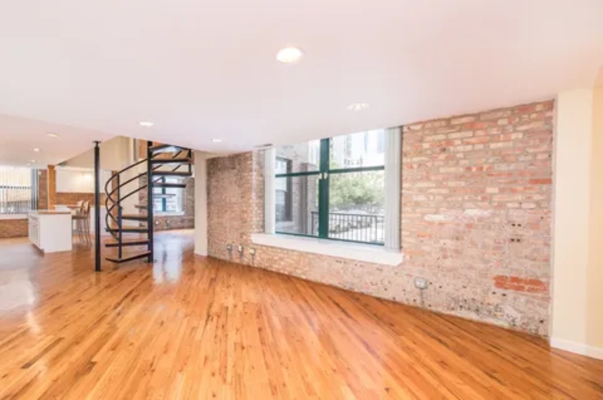 1439 South Michigan Avenue, Unit 101 Chicago, IL 60605 - Photo 7 of 14 a view of an empty room with a window and wooden floor