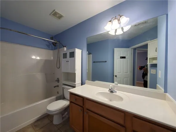 a bathroom with a sink a toilet a mirror and shower