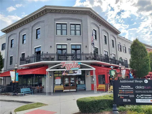 a front view of multi story building with retail shops