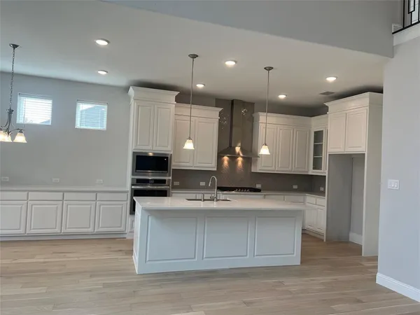 a large kitchen with stainless steel appliances kitchen island granite countertop a stove a sink and a refrigerator