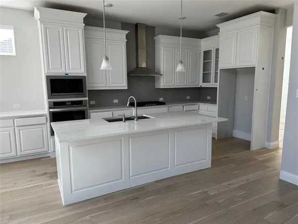 a kitchen with stainless steel appliances granite countertop a stove a sink and a refrigerator