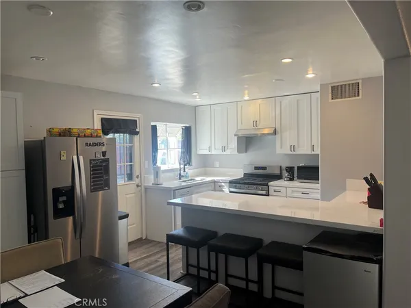 a kitchen with refrigerator and chairs