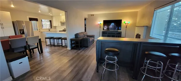 a living room with furniture a flat screen tv and wooden floor