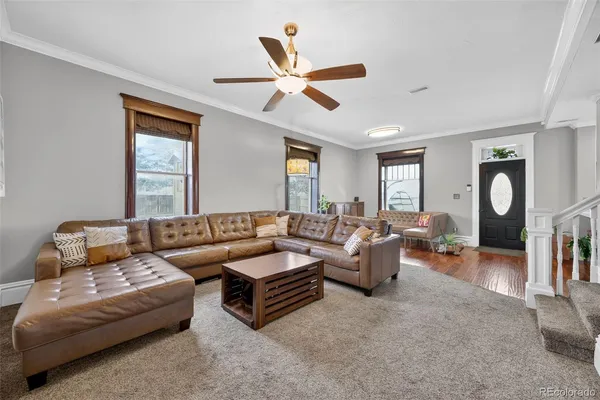 a living room with furniture a ceiling fan and a window