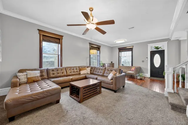 a living room with furniture a ceiling fan and a window