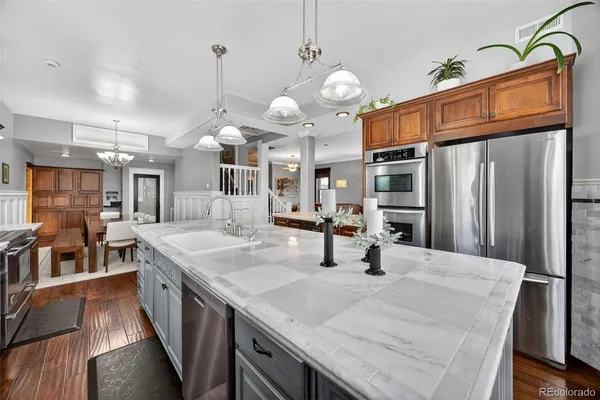a kitchen with stainless steel appliances granite countertop a sink refrigerator and cabinets