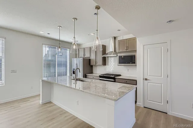 a kitchen with stainless steel appliances a sink stove and refrigerator