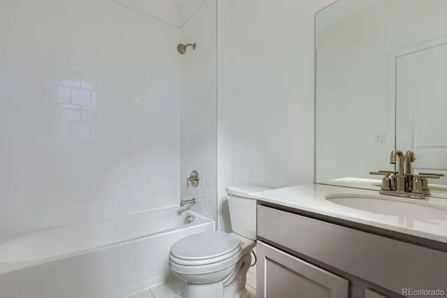 a bathroom with a sink toilet vanity and tub