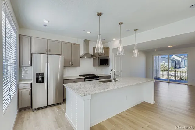 a kitchen with a refrigerator a sink and wooden floor