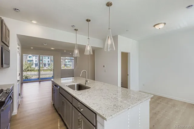 a kitchen with stainless steel appliances granite countertop a sink and a refrigerator