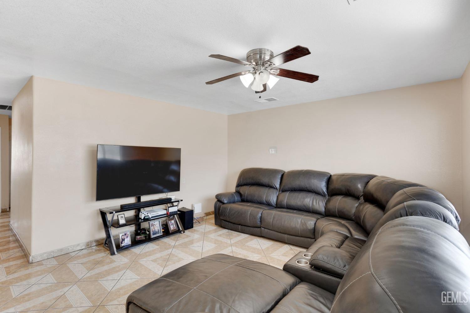 Undisclosed Address Bakersfield, CA 93307 - Photo 11 of 42 a living room with furniture and a flat screen tv