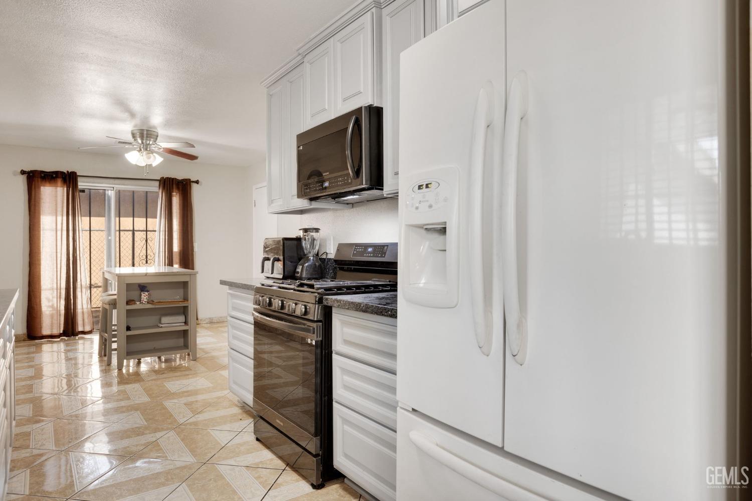 Undisclosed Address Bakersfield, CA 93307 - Photo 15 of 42 a kitchen with stainless steel appliances a stove microwave and cabinets