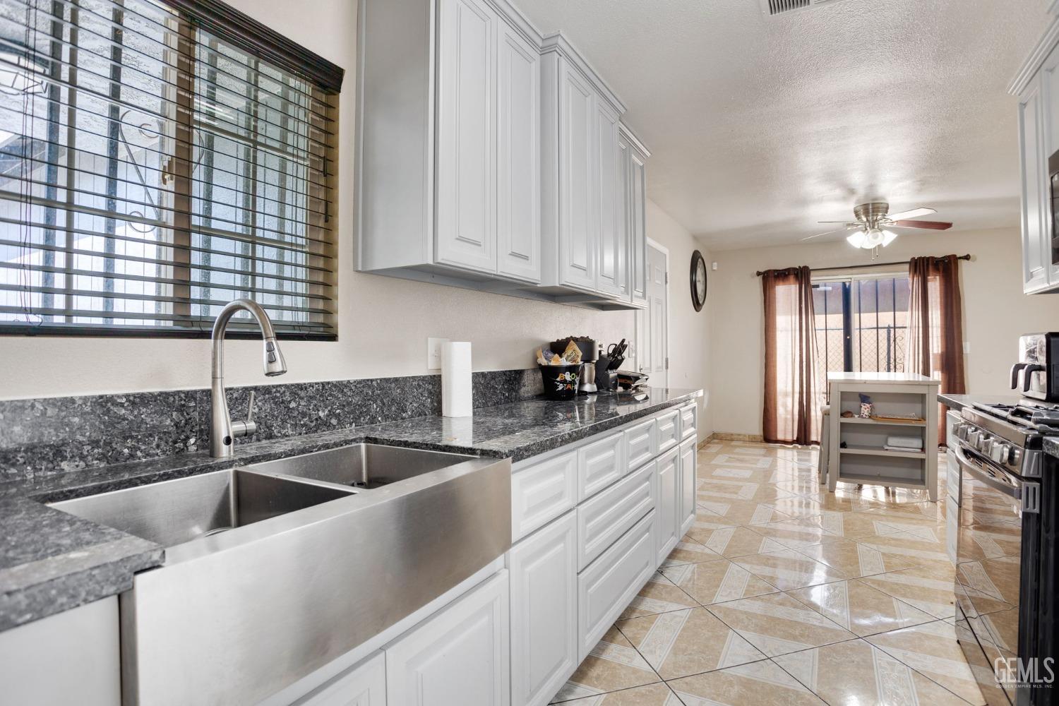 Undisclosed Address Bakersfield, CA 93307 - Photo 16 of 42 a kitchen with granite countertop a sink and cabinets