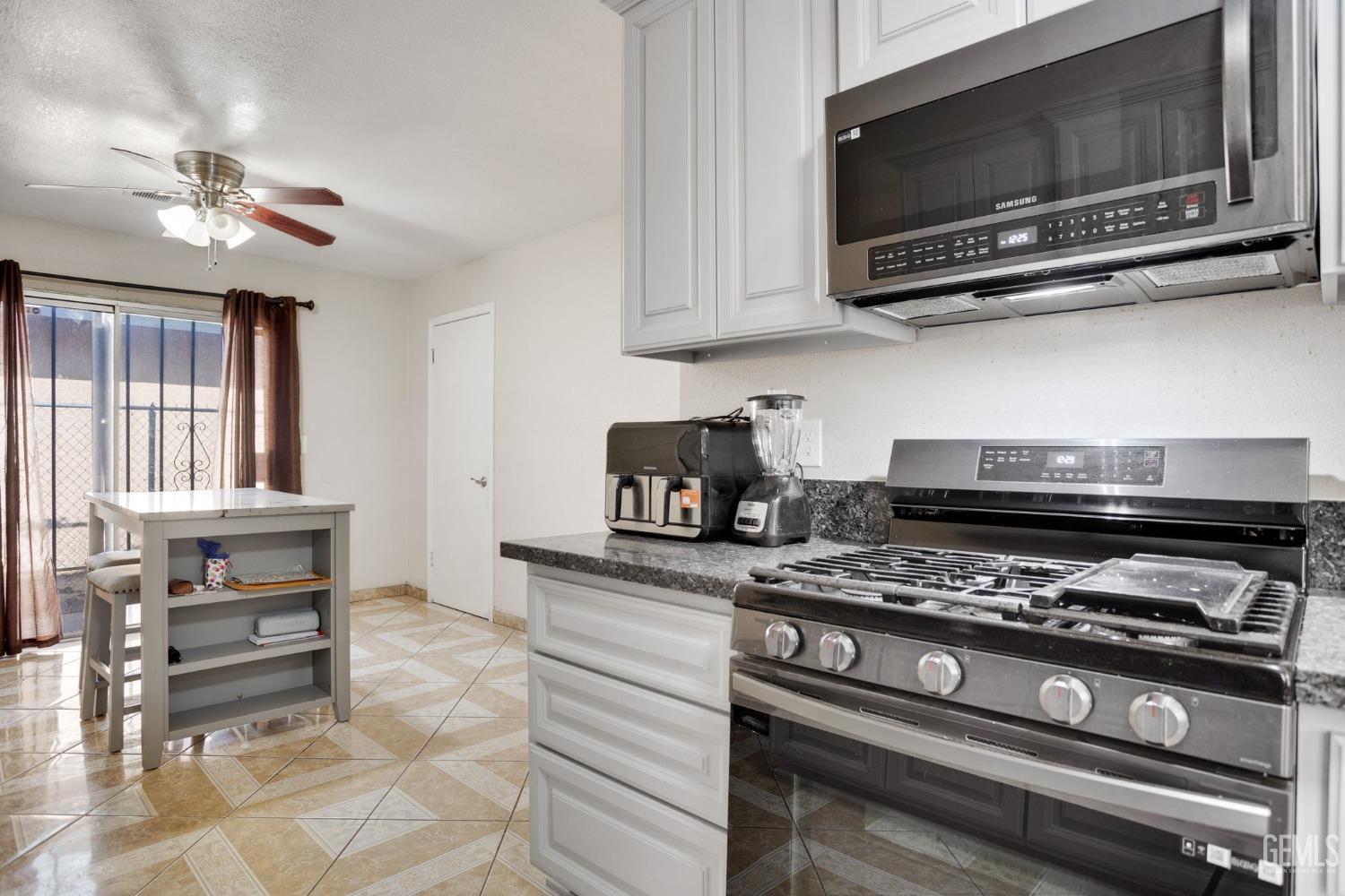 Undisclosed Address Bakersfield, CA 93307 - Photo 17 of 42 a kitchen with stainless steel appliances a stove a microwave and cabinets