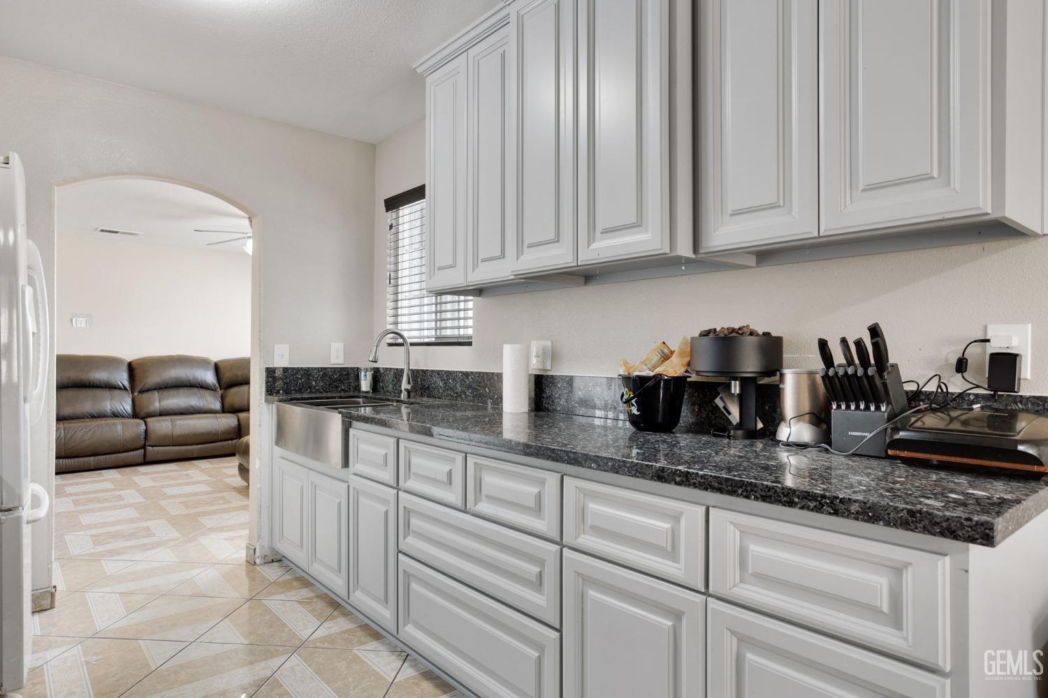 Undisclosed Address Bakersfield, CA 93307 - Photo 18 of 42 a kitchen with granite countertop a sink a stove and cabinets