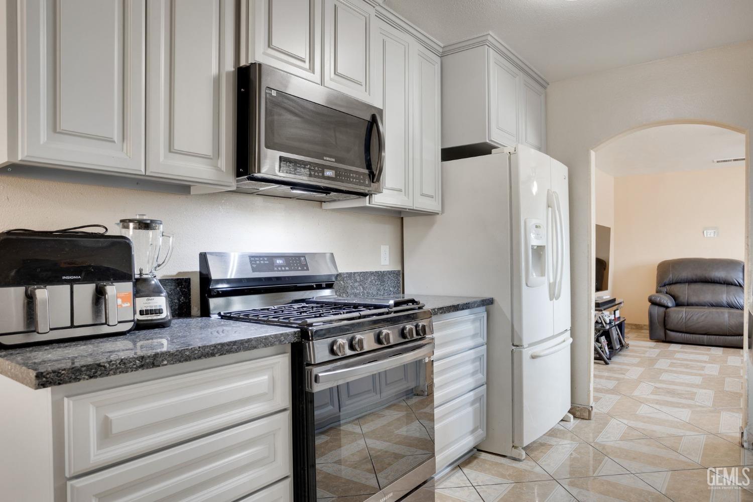Undisclosed Address Bakersfield, CA 93307 - Photo 19 of 42 a kitchen with stainless steel appliances granite countertop a stove microwave and refrigerator