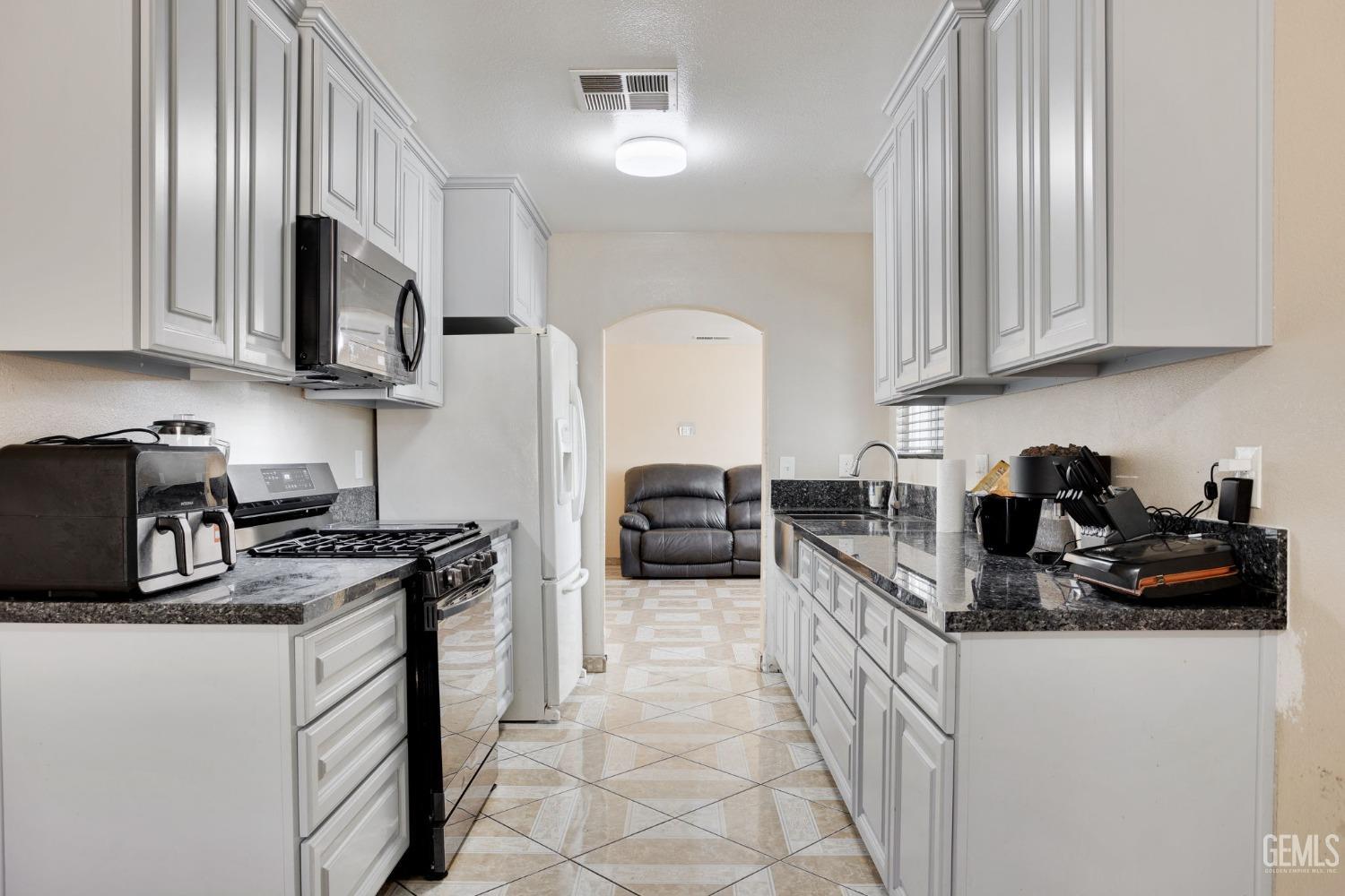 Undisclosed Address Bakersfield, CA 93307 - Photo 23 of 42 a kitchen with a sink stove and microwave