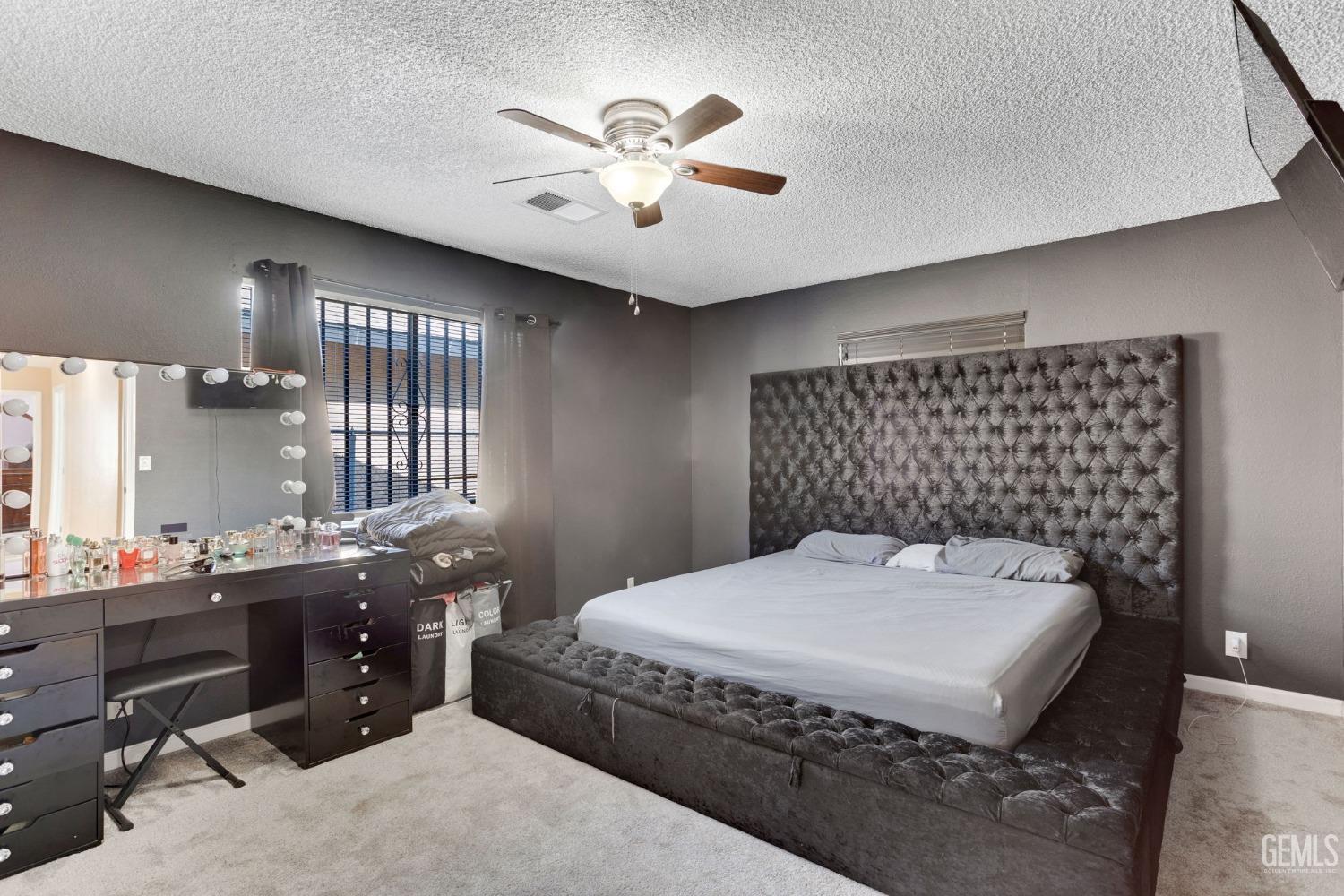 Undisclosed Address Bakersfield, CA 93307 - Photo 24 of 42 a spacious bedroom with a bed and a chandelier