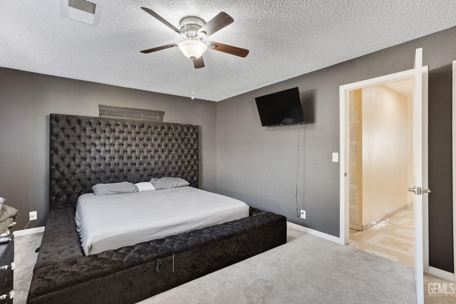 Undisclosed Address Bakersfield, CA 93307 - Photo 25 of 42 a spacious bedroom with a bed and a flat screen tv