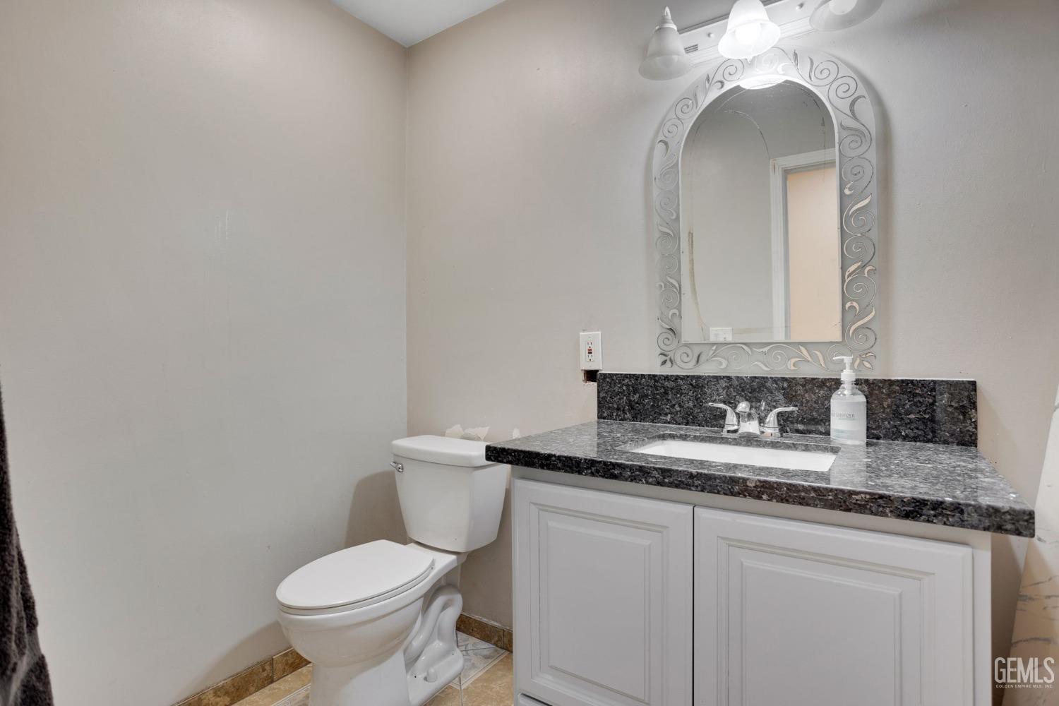 Undisclosed Address Bakersfield, CA 93307 - Photo 32 of 42 a bathroom with a toilet sink and mirror