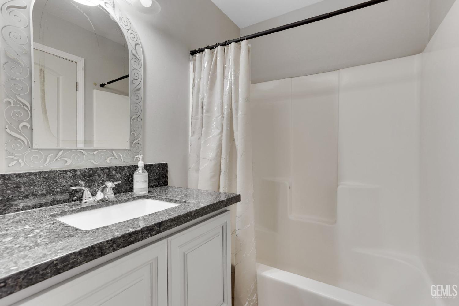 Undisclosed Address Bakersfield, CA 93307 - Photo 33 of 42 a bathroom with a granite countertop sink and a mirror