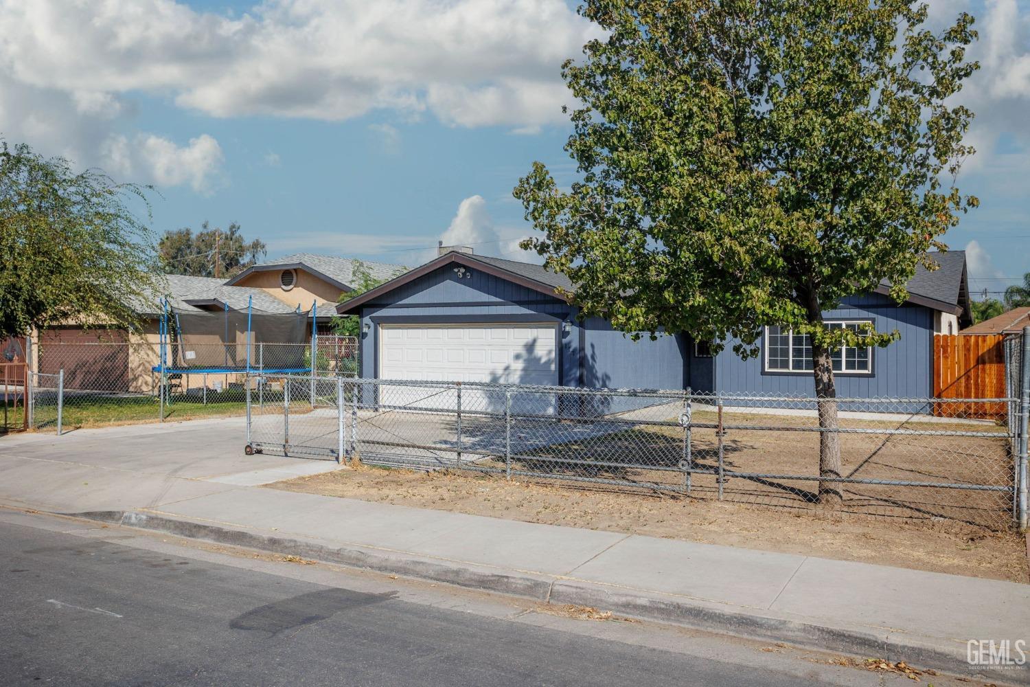 Undisclosed Address Bakersfield, CA 93307 - Photo 7 of 42 a view of a house with a street and trees