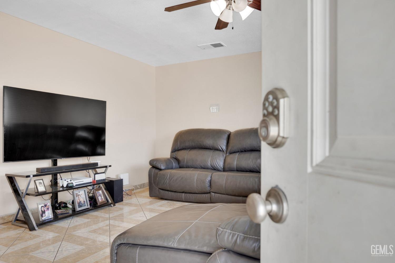 Undisclosed Address Bakersfield, CA 93307 - Photo 9 of 42 a living room with furniture and a flat screen tv