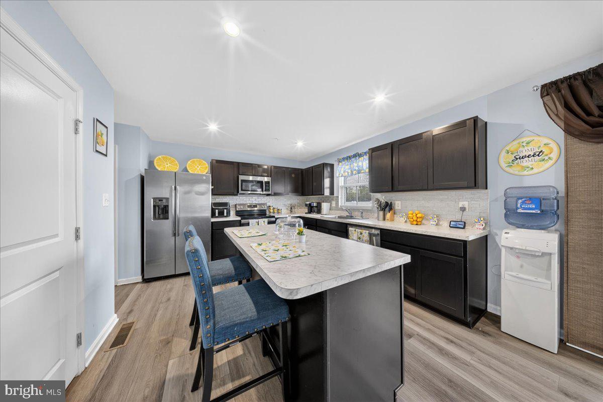 2 Ridgely Forest Drive Elkton, MD 21921 - Photo 10 of 35 a kitchen with stainless steel appliances kitchen island granite countertop a refrigerator a stove top oven a sink dishwasher and white cabinets with wooden floor
