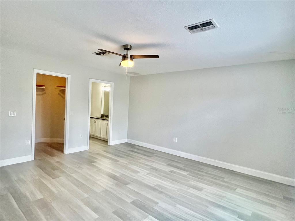 12368 Killian Street Spring Hill, FL 34609 - Photo 13 of 25 a view of empty room with wooden floor and ceiling fan