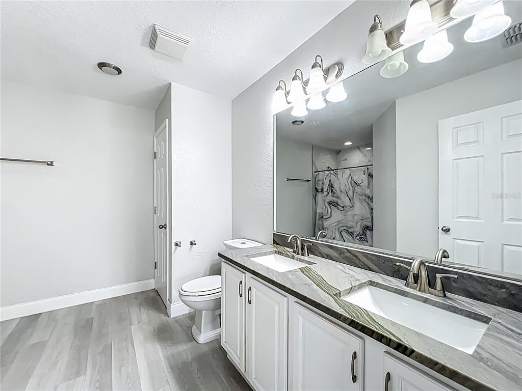 12368 Killian Street Spring Hill, FL 34609 - Photo 14 of 25 a bathroom with a sink double vanity granite and a toilet