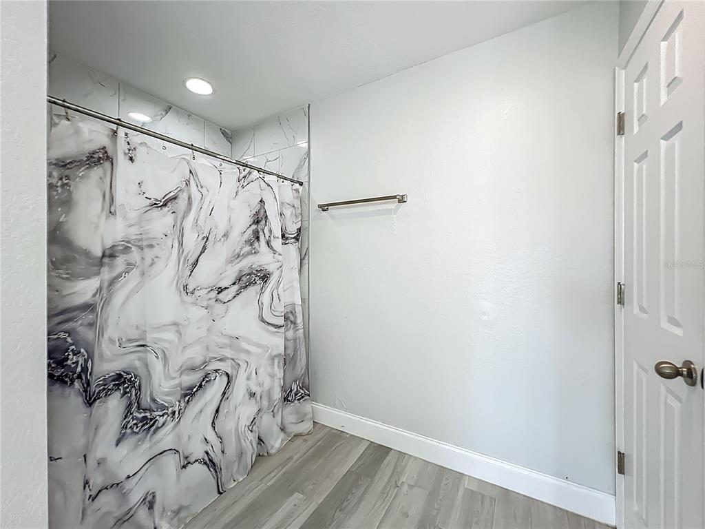 12368 Killian Street Spring Hill, FL 34609 - Photo 15 of 25 a bathroom with a shower curtain and a shower curtain