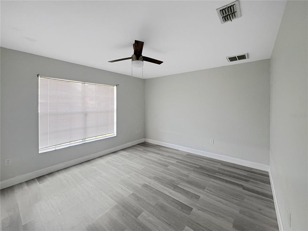 12368 Killian Street Spring Hill, FL 34609 - Photo 16 of 25 wooden floor in an empty room with a window