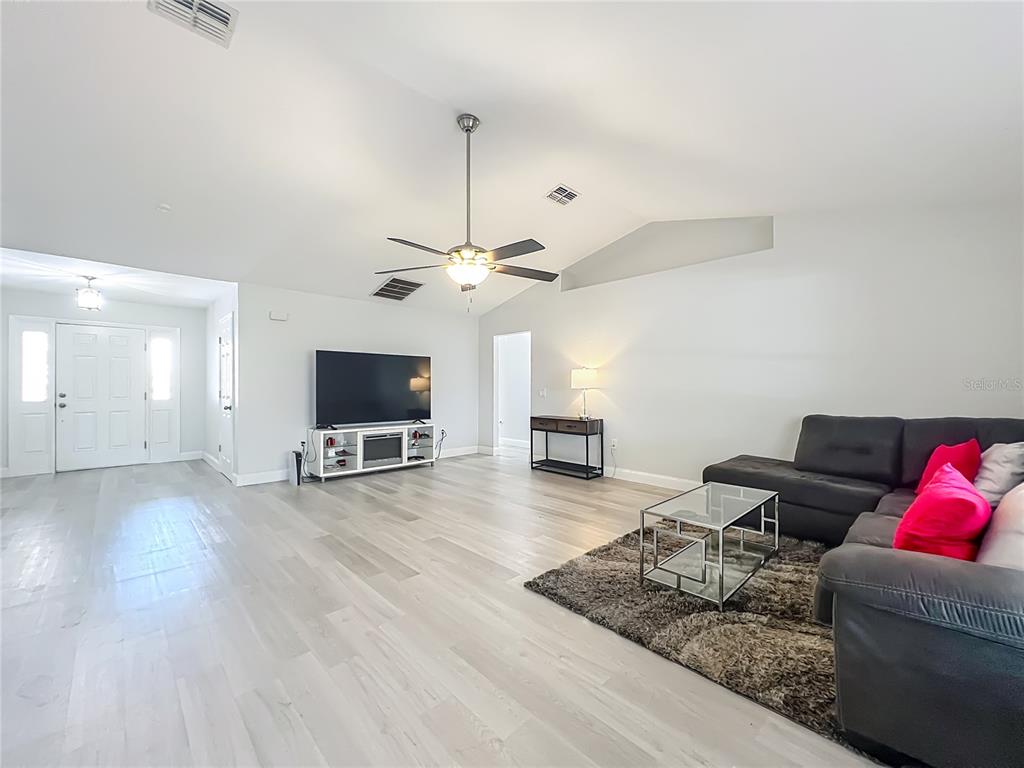 12368 Killian Street Spring Hill, FL 34609 - Photo 5 of 25 a living room with furniture and a flat screen tv