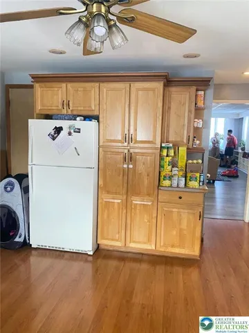 a view of a kitchen with fridge and wooden floor