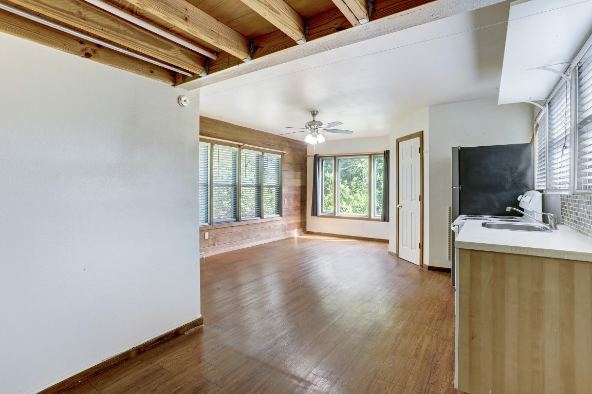 a view of an empty room with a window and wooden floor