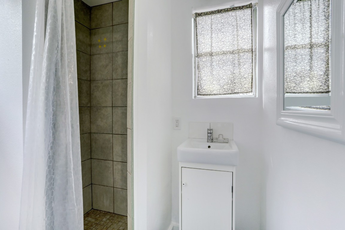 901 Newman Drive, Unit B Austin, TX 78703 - Photo 7 of 9 a bathroom with a sink a mirror and a window