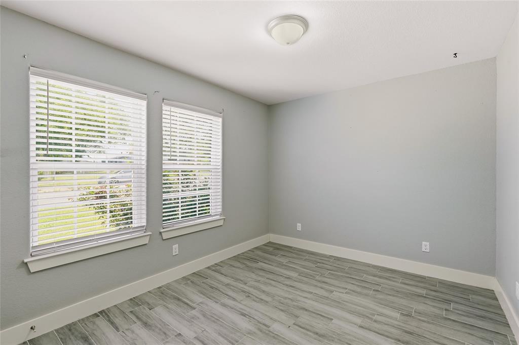 318 Munson Street Denison, TX 75021 - Photo 14 of 21 a view of an empty room with wooden floor and a window