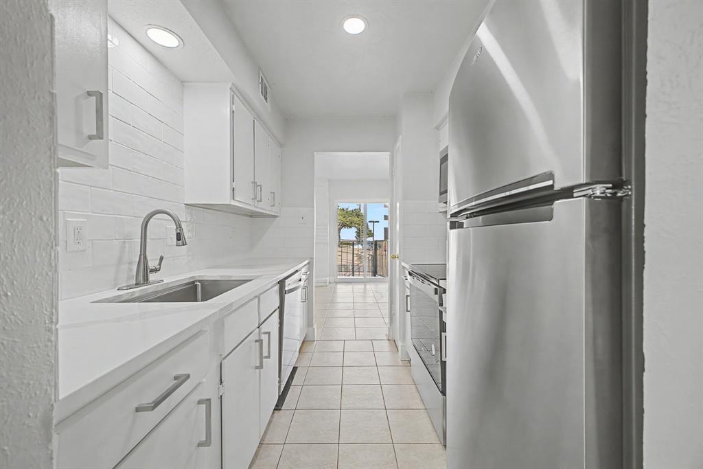 8095 Meadow Road, Unit 236 Dallas, TX 75231 - Photo 11 of 25 a kitchen with a sink and refrigerator