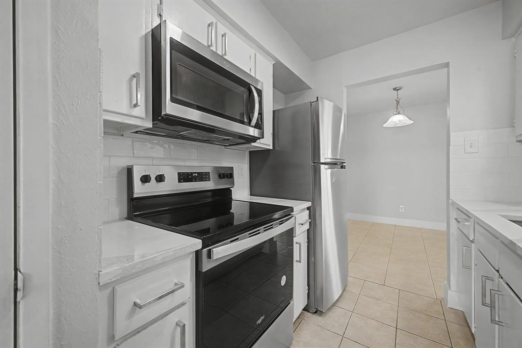 8095 Meadow Road, Unit 236 Dallas, TX 75231 - Photo 13 of 25 a kitchen with stainless steel appliances granite countertop a stove microwave and refrigerator