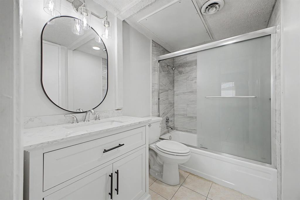 8095 Meadow Road, Unit 236 Dallas, TX 75231 - Photo 17 of 25 a bathroom with a toilet a sink and a mirror