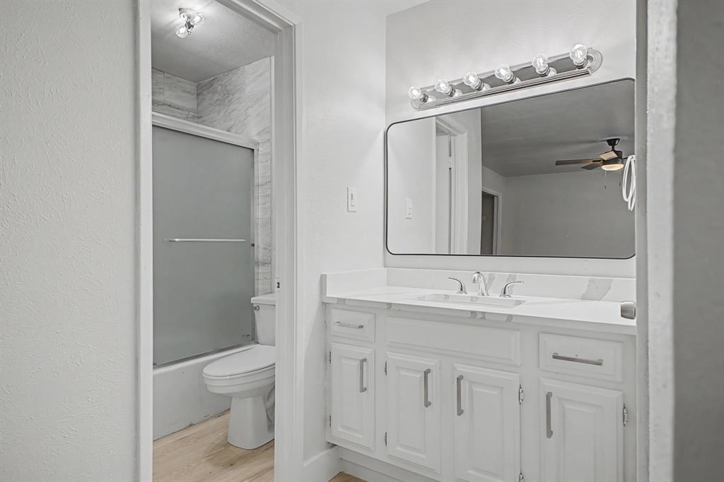 8095 Meadow Road, Unit 236 Dallas, TX 75231 - Photo 3 of 25 a bathroom with a toilet sink and mirror