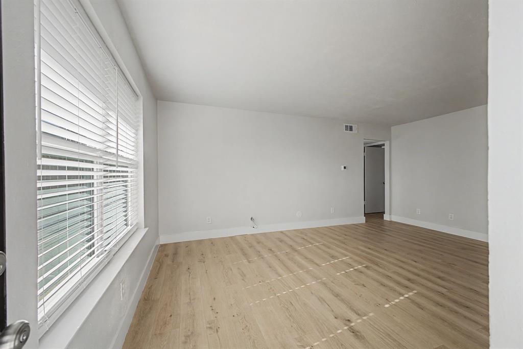 8095 Meadow Road, Unit 236 Dallas, TX 75231 - Photo 5 of 25 an empty room with wooden floor and windows