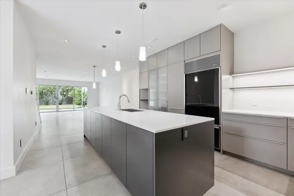 a large kitchen with kitchen island a sink stainless steel appliances and cabinets
