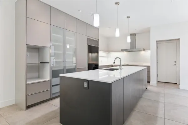 a kitchen with a sink refrigerator and cabinets