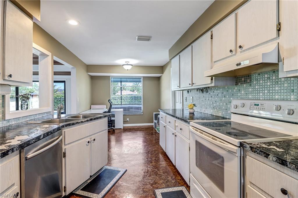 103 Doral Circle Naples, FL 34113 - Photo 10 of 25 a kitchen with granite countertop a sink stove and cabinets