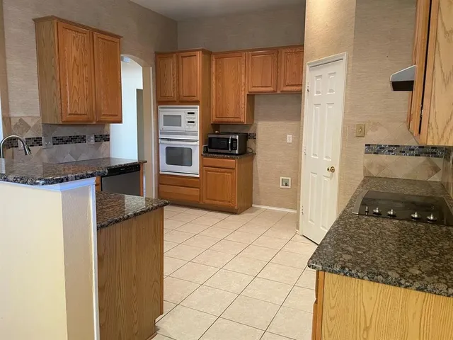 a kitchen with granite countertop a refrigerator and a stove